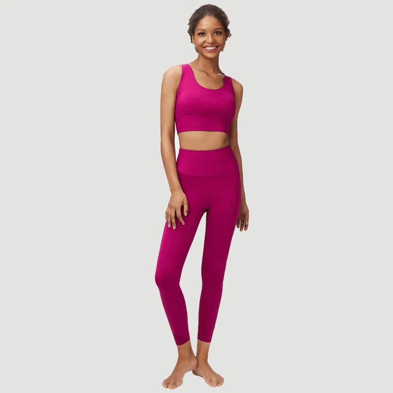 Woman wearing seamless yoga gear set in vivid pink for active women, featuring a sports bra and leggings, perfect for workouts.